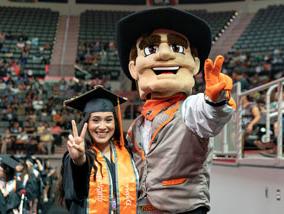 金沙中国 mascot graduate poses beside graduate